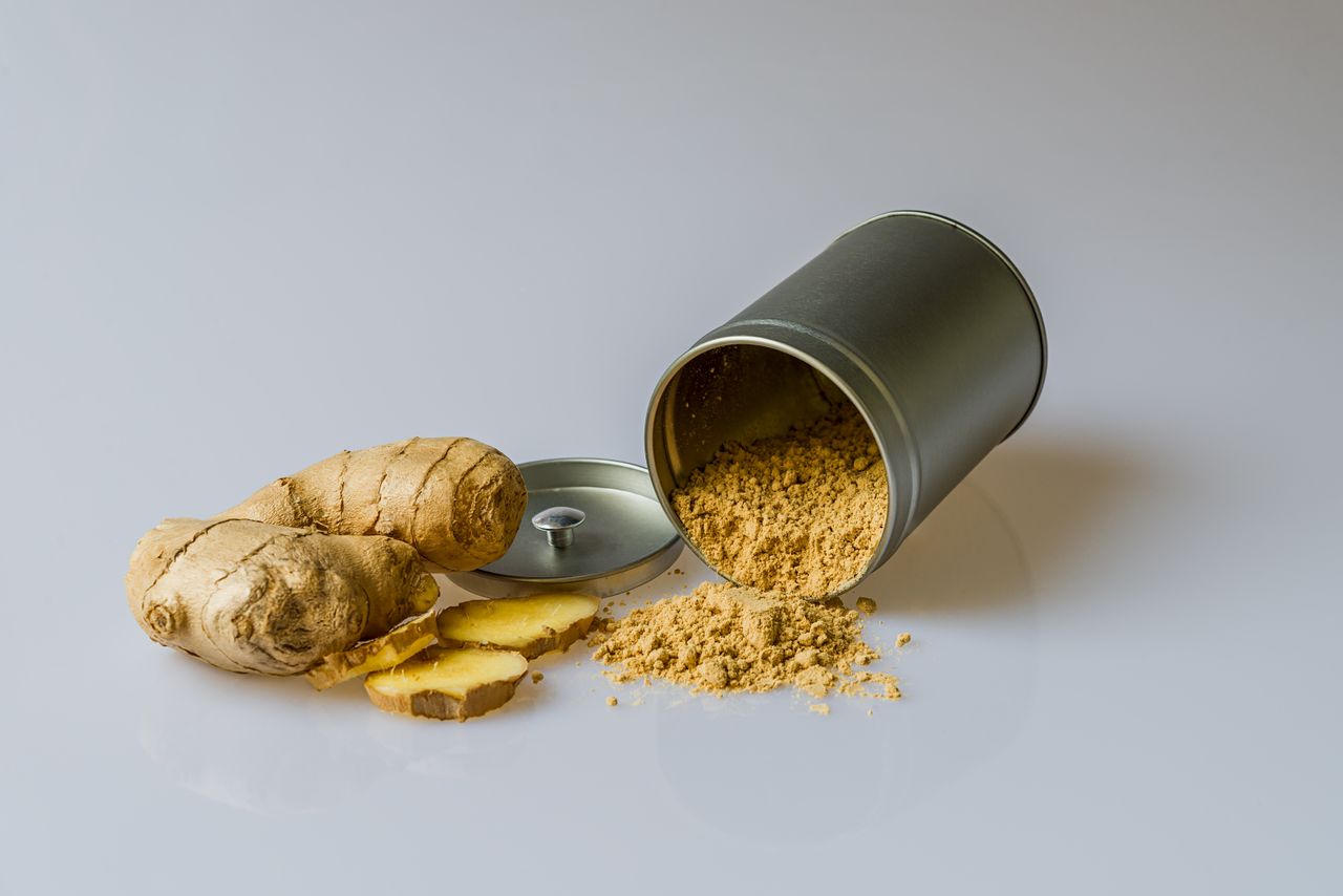 services-01 Close-up of fresh ginger root with sliced pieces and ginger powder spilled from a metal container.