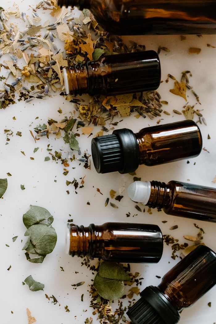 The Art of Drawing Readers In: Your attractive post title goes here Flat lay of amber glass bottles and dried herbs for aromatherapy on a white surface.